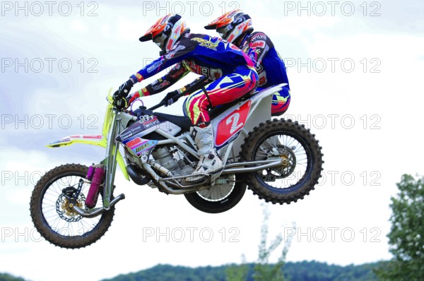Motocross, Rudersberg, Baden-Württemberg, Germany, Europe, Two motorbike racers in colourful suits jumping over a race track, Rudersberg motocross