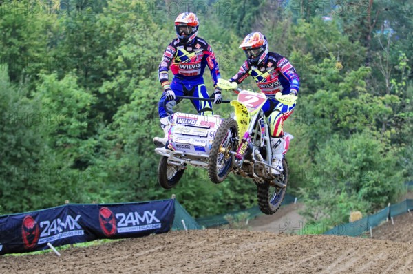 Motocross, Rudersberg, Baden-Württemberg, Germany, Europe, Two riders on a sidecar motorbike jump over a mound of earth on a race track in the forest, Rudersberg Motocross
