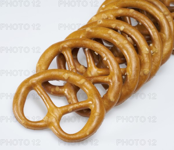 Some lye pretzels in a row in light back