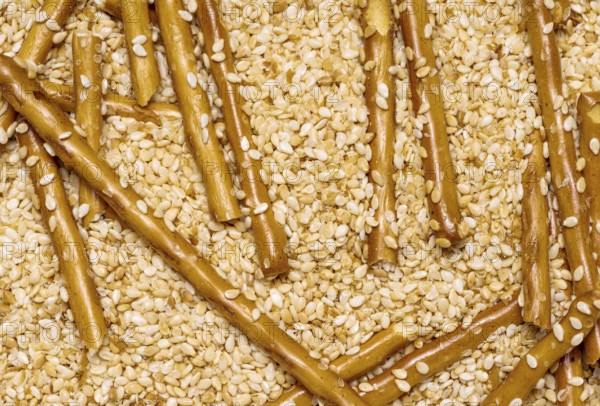 Full frame closeup of some baked sesame sticks in sesame back