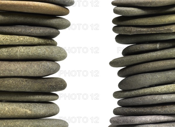 Low angle view of two flat pebble stone stacks in light back