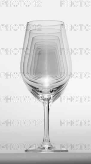 Some clean and empty wine glasses standing in a row in light grey back