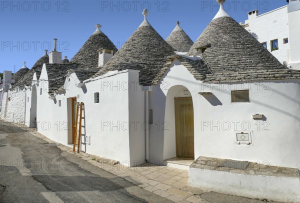 Sunny impression of trulli houses at a town named Alberobello in Apulia, Italy