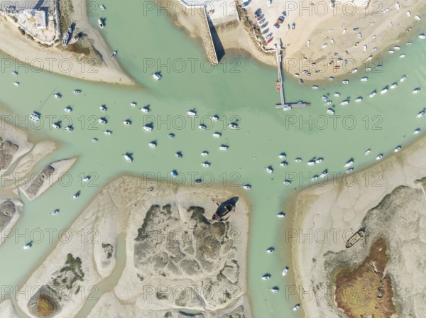 Fishing boats at low tide at the fishing village of Sancti Petri. In the marshland of the Bahía de Cádiz Nature Reserve. Aerial view.. Drone shot. Cádiz province, Andalusia, Spain