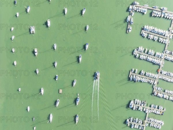 Sports and fishing boats at the marina of the fishing village of Sancti Petri. In the marshland of the Bahía de Cádiz Nature Reserve. Aerial view.. Drone shot. Cádiz province, Andalusia, Spain