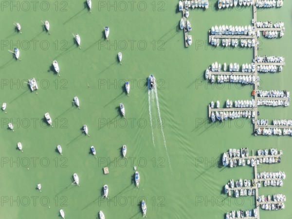Sports and fishing boats at the marina of the fishing village of Sancti Petri. In the marshland of the Bahía de Cádiz Nature Reserve. Aerial view.. Drone shot. Cádiz province, Andalusia, Spain