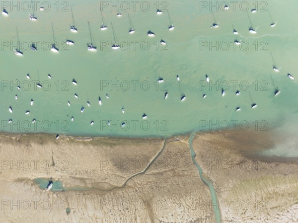 Sports and fishing boats at low tide near the fishing village of Sancti Petri. In the marshland of the Bahía de Cádiz Nature Reserve. Aerial view.. Drone shot. Cádiz province, Andalusia, Spain