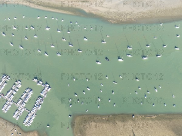 Sports and fishing boats at the marina of the fishing village of Sancti Petri. In the marshland of the Bahía de Cádiz Nature Reserve. Aerial view.. Drone shot. Cádiz province, Andalusia, Spain