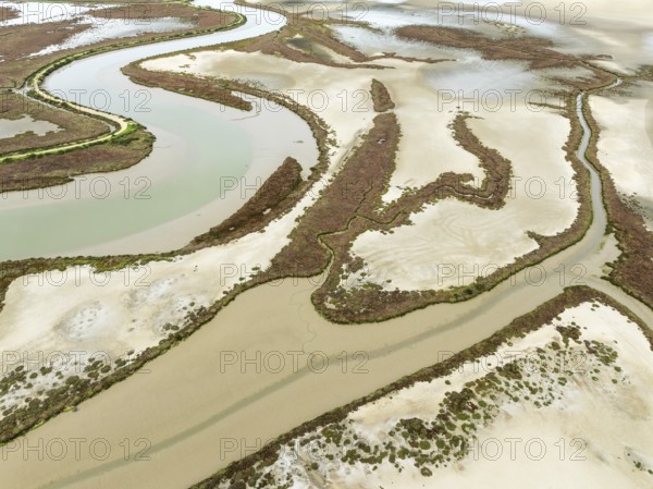 The Barbate river and surrounding marshland at low tide. Nature Reserve La Breña y Marismas del Barbate. Aerial view. Drone shot. Cádiz province, Andalusia, Spain