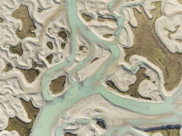 Network of channels and streams at low tide. In the marshland of the Bahía de Cádiz Nature Reserve. Aerial view. Drone shot. Cádiz province, Andalusia, Spain