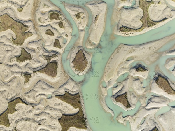 Network of channels and streams at low tide. In the marshland of the Bahía de Cádiz Nature Reserve. Aerial view. Drone shot. Cádiz province, Andalusia, Spain