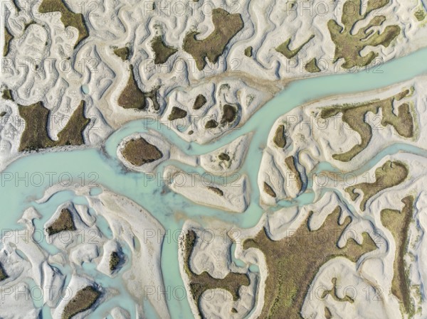 Network of channels and streams at low tide. In the marshland of the Bahía de Cádiz Nature Reserve. Aerial view. Drone shot. Cádiz province, Andalusia, Spain