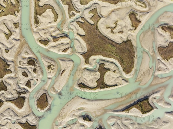 Network of channels and streams at low tide. In the marshland of the Bahía de Cádiz Nature Reserve. Aerial view. Drone shot. Cádiz province, Andalusia, Spain