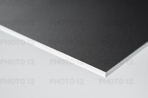 Edge of a black covered white board in light grey back