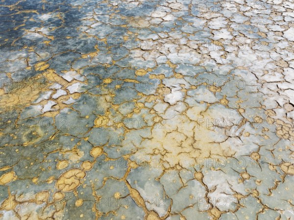 Abstract patterns in the shallow water of a saline pond in the marshland of the Bahía de Cádiz Nature Reserve. Aerial view. Drone shot. Cádiz province, Andalusia, Spain