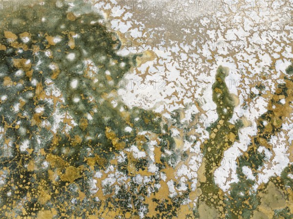 Abstract patterns in the shallow water of a saline pond in the marshland of the Bahía de Cádiz Nature Reserve. Aerial view. Drone shot. Cádiz province, Andalusia, Spain