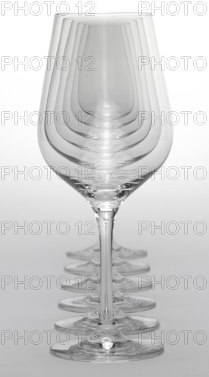 Some clean and empty wine glasses standing in a row in light grey back