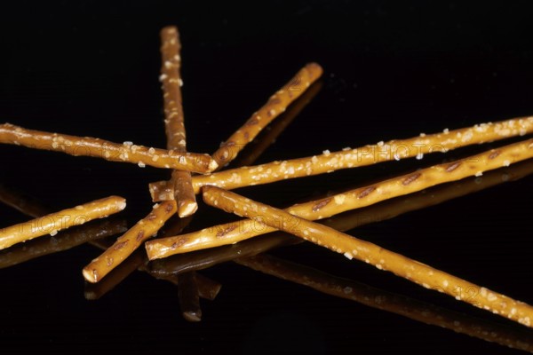 Closeup of some salt sticks on dark striped glossy ground