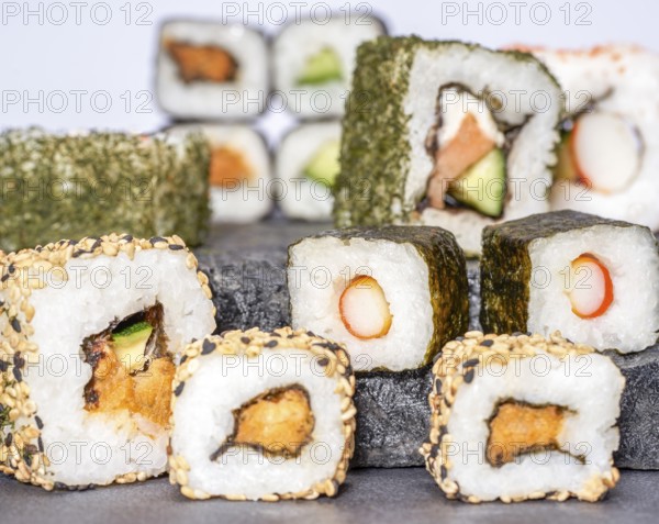 Various sushi dishes on dark grey stone surface