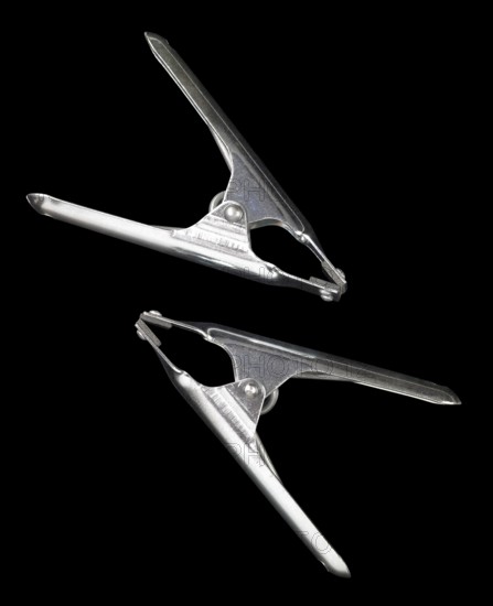 Studio photography of two metal clamps isolated on black