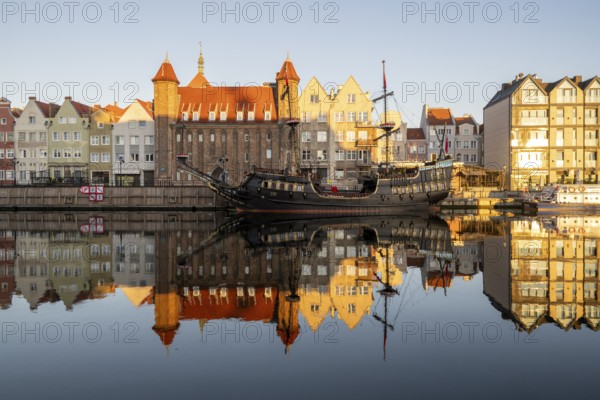 Waterfront promenade with reflection at sunrise in the Old Town, pirate ship, excursion boat, Motlawa River, Gdansk, Gdansk, Poland