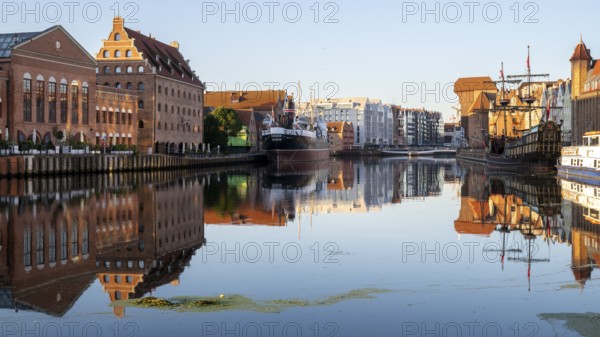 Waterfront promenade with reflection at sunrise in the Old Town, Motlawa River, Gdansk, Gdansk, Poland