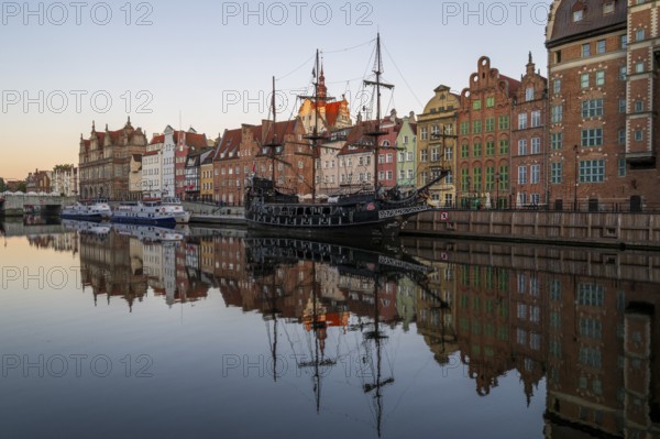 Waterfront promenade with reflection at sunrise in the Old Town, pirate ship, excursion boat, Motlawa River, Gdansk, Gdansk, Poland