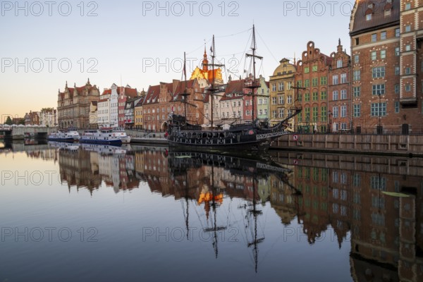 Waterfront promenade with reflection at sunrise in the Old Town, pirate ship, excursion boat, Motlawa River, Gdansk, Gdansk, Poland