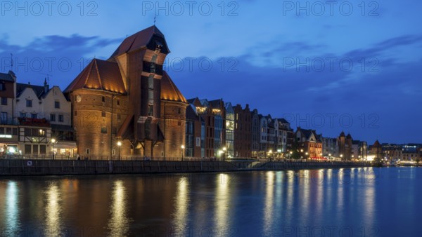 Illuminated waterfront promenade at sunset in the Old Town, Brama Zuraw crane gate, Motlawa River, Gdansk, Poland