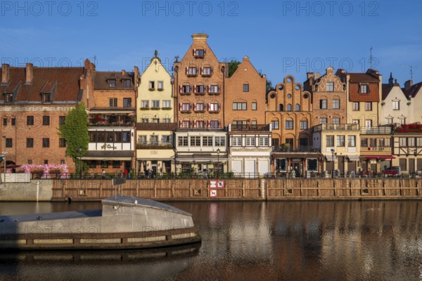 Waterfront promenade with reflection at sunrise in the Old Town, Motlawa River, Gdansk, Poland