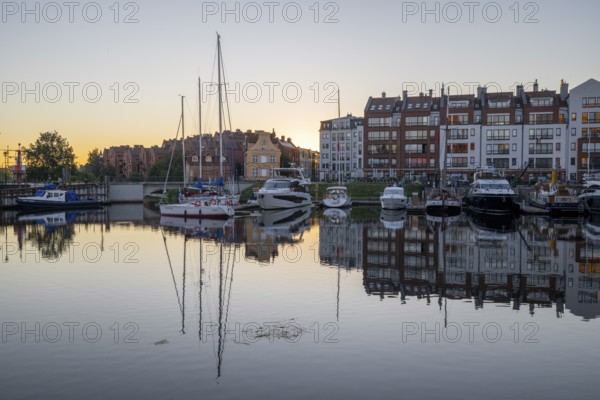 Waterfront promenade with reflection at sunrise in the old town, Motlawa river, boat harbour, Gdansk, Gdansk, Poland