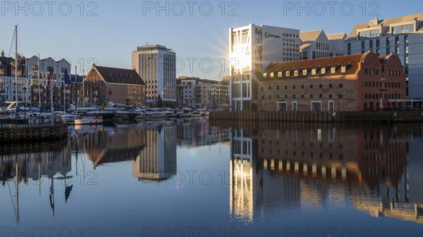 Waterfront promenade with reflection at sunrise in the Old Town, Motlawa River, Gdansk, Gdansk, Poland