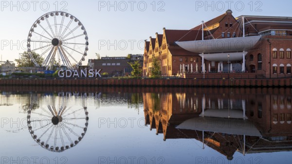 Ferris wheel on the waterfront with reflection at sunrise in the old town, Motlawa River, Gdansk, Gdansk, Poland