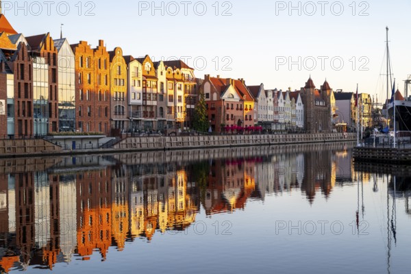 Waterfront promenade with reflection at sunrise in the Old Town, Motlawa River, Gdansk, Gdansk, Poland