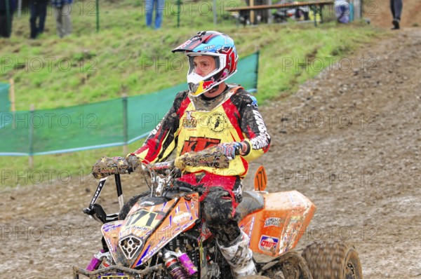 Motocross, Rudersberg, Baden-Württemberg, Germany, Europe, Motocross quad rider on muddy track with eye-catching helmet, Rudersberg motocross