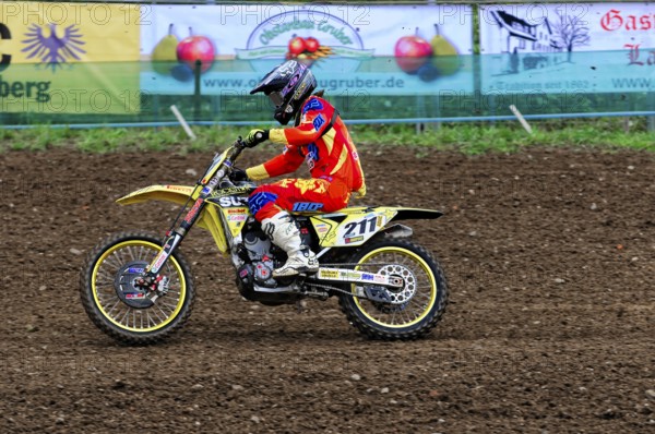 Motocross, Rudersberg, Baden-Württemberg, Germany, Europe, A rider on a yellow motorbike concentrates on the ride over a muddy track, Rudersberg Motocross