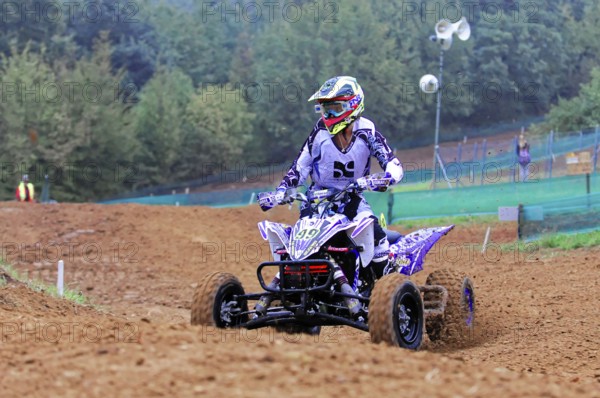 Motocross, Rudersberg, Baden-Württemberg, Germany, Europe, Quad bikers in purple colours on a race track in the mud, Rudersberg Motocross