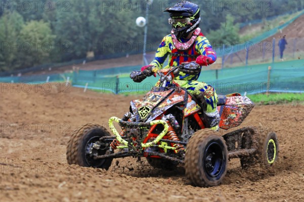 Motocross, Rudersberg, Baden-Württemberg, Germany, Europe, Colourful quad bike rider rides through mud on a race track, Rudersberg motocross