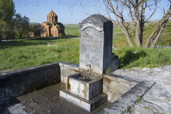 Stone fountain with engraving in front of a rural church in a green landscape, original spring, Heghnar, Marmashen Monastery, Marmashen Vank, Shirak Province, Armenia