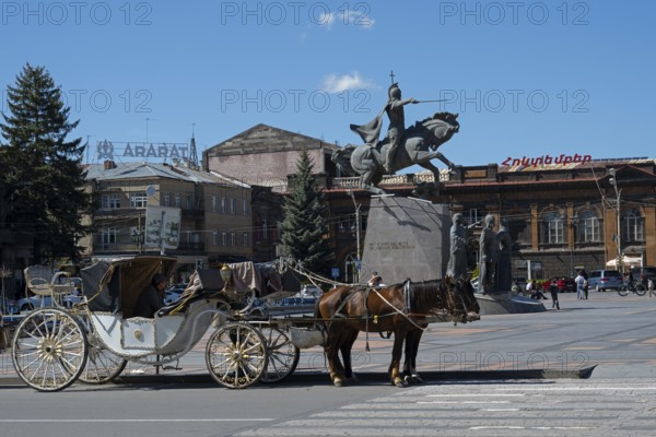 A decorative carriage with horses in front of a historical building with a statue, carriage in front of the monument to the Battle of Avarayr, Wardananz Hraparak, Wardananz Square, Vartanants, Gyumri, Gyumri, Shirak Province, Armenia