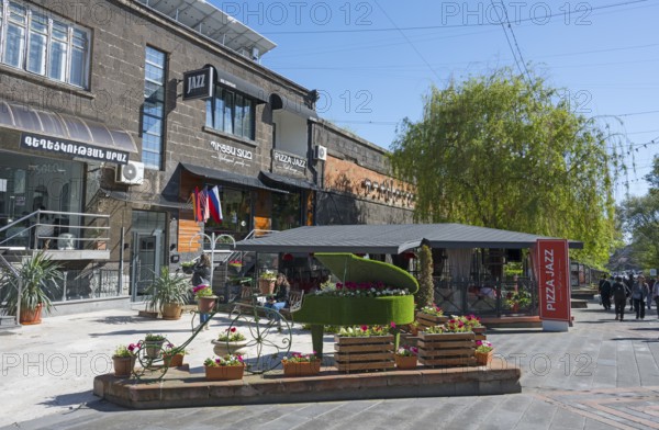Lively street scene with a decorated piano, flowering plants and pretty buildings on a sunny day, Gyumri, Gyumri, Shirak Province, Armenia