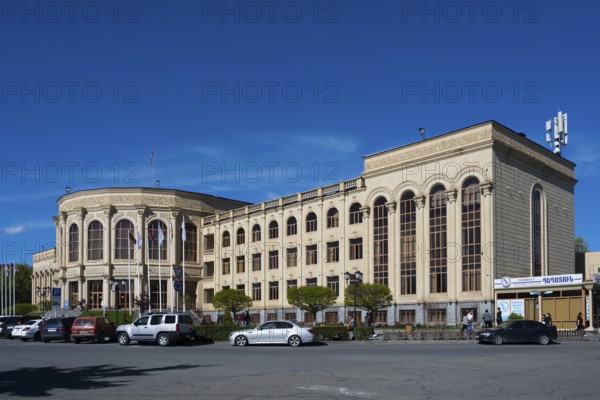 Large historic building in the city centre under a blue sky with parked cars, Gyumri, Gyumri, Gyumri, Shirak Province, Armenia