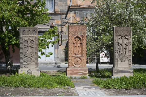 Three artistically engraved khachkars stand in a green setting, cross stones, khachkars, Gyumri, Gyumri, Shirak Province, Armenia