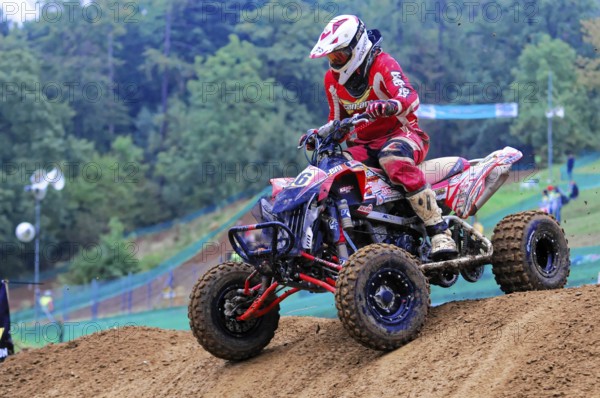 Motocross, Rudersberg, Baden-Württemberg, Germany, Europe, Rider in red protective clothing jumps over a hill on a quad bike during an off-road race, Rudersberg motocross