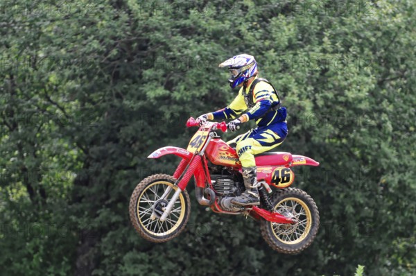 Motocross, Rudersberg, Baden-Württemberg, Germany, Europe, Motocross rider on a red motorbike in flight during a race through wooded area, Rudersberg motocross