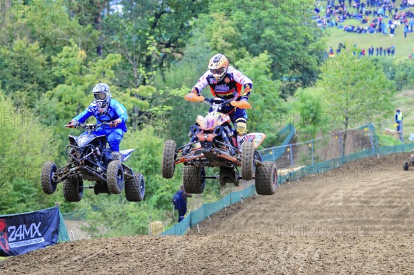 Motocross, Rudersberg, Baden-Württemberg, Germany, Europe, Two quads jump synchronised over a track, watched by spectators in the background, Rudersberg motocross