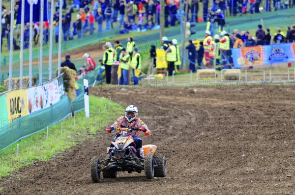 Motocross, Rudersberg, Baden-Württemberg, Germany, Europe, A quad bike pilot navigates through a muddy track while spectators watch in the background, Rudersberg Motocross