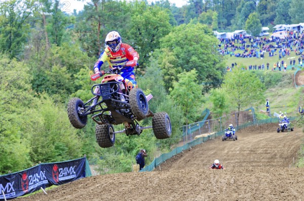 Motocross, Rudersberg, Baden-Württemberg, Germany, Europe, A quadbike drives in the air over a track while spectators watch the spectacle, Rudersberg Motocross