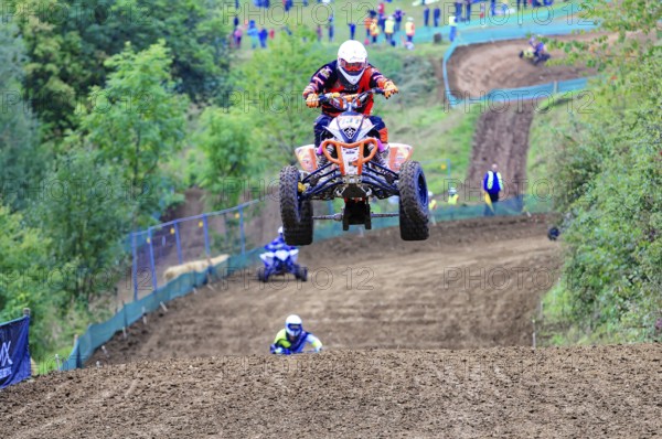 Motocross, Rudersberg, Baden-Württemberg, Germany, Europe, A quad bike rider jumps over a track elevation while other riders can be seen behind, Rudersberg Motocross