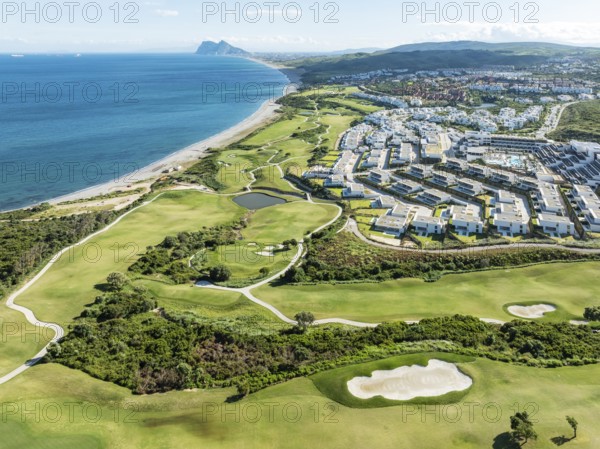 The La Hacienda Links Golf Resort at the Mediterranean Sea with the Rock of Gibraltar (British) in the distance. Prominent the Fairmont La Hacienda hotel. Aerial view. Drone shot. Cádiz province, Andalusia, Spain